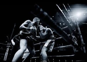 Powerful boxing match between two athletes inside the ring, showcasing intensity and strength.