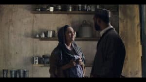 Compelling scene from Lift-Off Global Network featuring intense dialogue between two characters in a rustic kitchen setting.