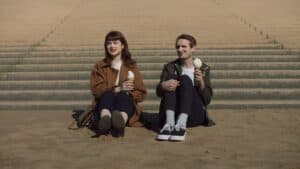 Enjoying ice cream on the steps, young couple relaxing and having fun, lifestyle, outdoor leisure, casual fashion.