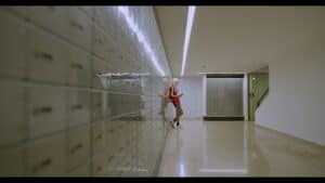 Empty lobby with a woman using a smartphone near mailboxes, modern space, minimalist design, corporate environment.